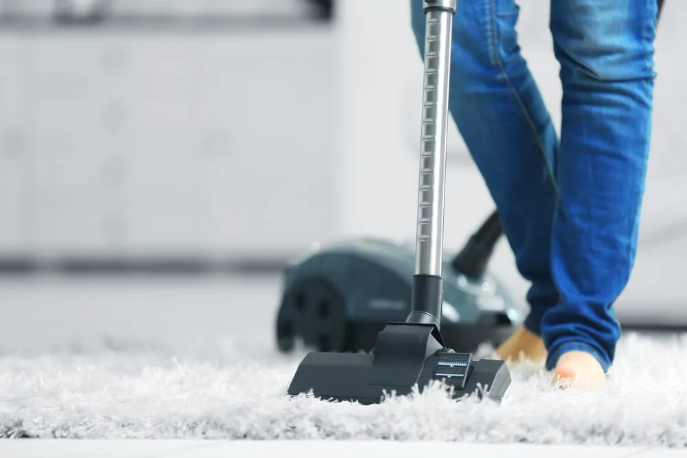 woman,cleaning,the,carpet,with,vacuum,cleaner,in,the,living